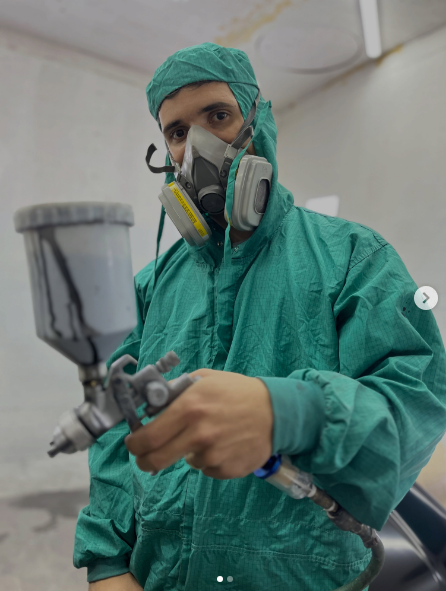 Pintor da Souza Car com equipamento de proteção e pistola de pintura
